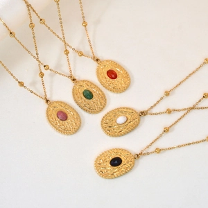 Detail of vintage pea pendant necklaces with assorted natural stones on white satin