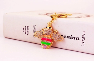 Close-up of golden bee keychain with colorful enamel body and sparkling crystal rhinestones