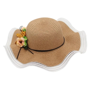 Détail d'un chapeau de paille kaki avec bord blanc ondulé et fleurs orange