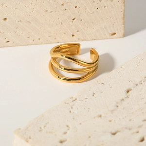 Minimalist 18K gold plated three-layer wave open ring on a beige travertine stone