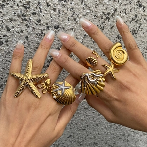 Gold stainless steel ocean-themed rings with starfish and pearls on a model hand