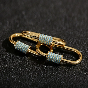 Detail of gold-plated screw clasp pendant with micro-set light blue decorative stones