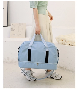 Detail view of the light blue travel bag showing the bottom expansion compartment