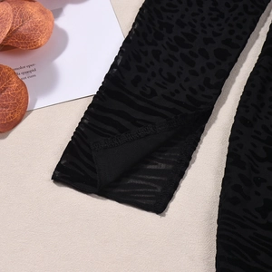 Gros plan du tissu en tulle noir à flocage léopard sur une robe moulante sexy