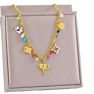 Bohemian gold necklace featuring elephant pendants and colorful beads on a premium grey box