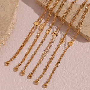 Detailed close-up of golden multi-layered chains with star, heart, and feather charms