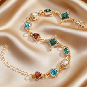 Makroaufnahme eines bunten Edelsteinarmbandes mit Vergoldung auf luxuriösem Satin