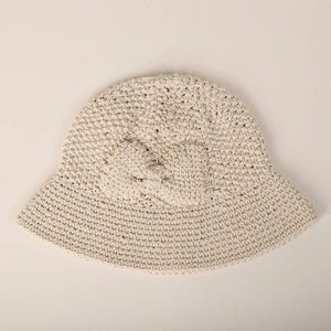 Vue détaillée du dessus d'un chapeau cloche en coton beige crocheté à la main avec nœud