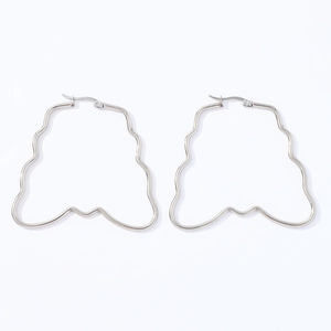 Macro detail of large silver wavy geometric earrings with a polished metallic finish