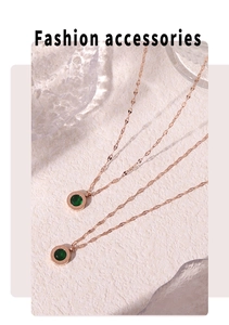 Détail du collier en titane or rose avec pierre émeraude et chiffres romains gravés