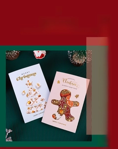 Detail of laser-cut Christmas cards featuring festive 3D tree and gingerbread man designs