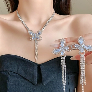 Close-up of silver butterfly jewelry set with rhinestones and long tassels on a model