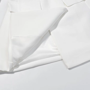 Detailed macro view of the smooth white fabric and inner lining of a blazer dress