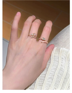 Detail of s925 silver flower rings with pink stones and teardrop zircon on a hand