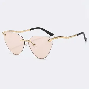 Fashionable rimless cat eye sunglasses with wavy gold metal temples and tinted lenses