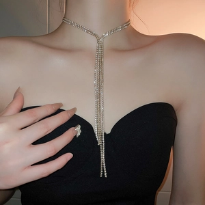 Details der eleganten langen Gold-Quastenkette mit Strasssteinen am weiblichen Model
