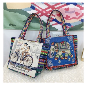 Detail view of woven canvas tote bags featuring ethnic patterns and elephant motifs