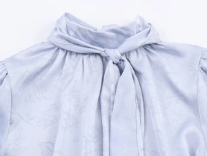 Detailansicht des Stehkragens mit Seidensatin-Blumenjacquard und eleganter Schleife