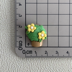 Vue détaillée d'une breloque pot de fleur en résine de 2cm sur tapis gradué