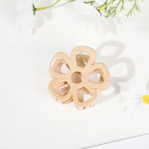 Detailed macro view of beige flower hair claw clip with spring on white background