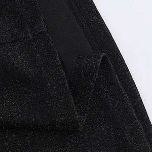 Detail of black shimmering fabric with fine glitter particles and precise stitching