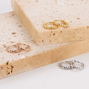 Three pairs of hammered stainless steel hoop earrings in gold, silver and rose gold