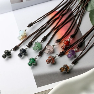 Macro detail of handmade wire wrapped skull necklaces with various natural crystal pendants