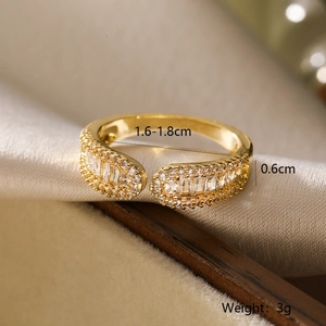 Macro detail of gold plated 18K ring with geometric zircons on champagne silk fabric