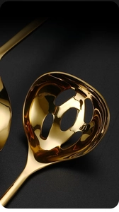 Macro detail of golden stainless steel slotted spoon with uniform drainage holes