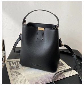 Detail der schwarzen Bucket Bag aus Leder mit FASHION Prägung und Goldverschluss