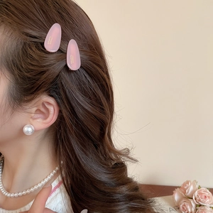 Gros plan de pinces à cheveux roses mates et perles sur le profil d'un mannequin