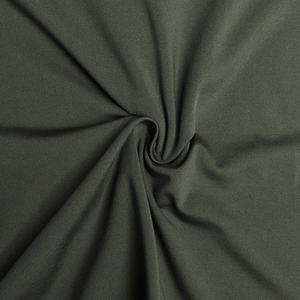 Vue macro d'un tissu en maille vert olive avec drapé doux pour robes élégantes