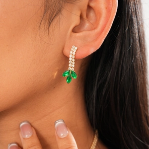 Détail de boucles d'oreilles épi de blé avec pierres vertes et zircons sur modèle