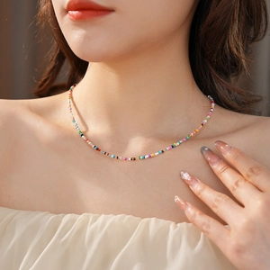 Close-up of model wearing a colorful beaded necklace in a vibrant bohemian style