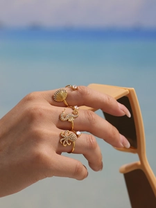 Detailed macro of gold plated rings featuring seashell, seahorse and octopus designs