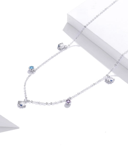 Macro shot of S925 silver shell necklace with blue and purple zircons on white stage
