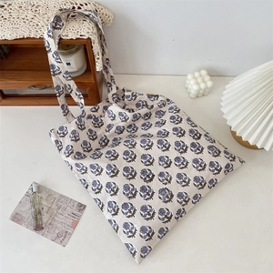 Detail of vintage floral canvas tote bag showing blue flower prints and sturdy fabric