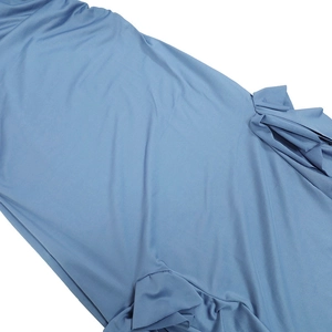Close-up of soft blue fabric texture and smooth flowing drapes of the beach dress