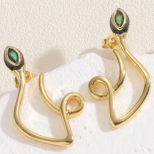 Detailed macro shot of gold-plated snake earrings with green zircon eyes and black enamel
