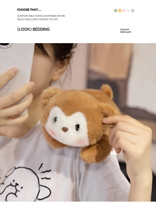 Close-up of a soft brown plush bear doll with pink cheeks attached to a girl's shoulder
