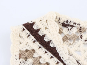 Detail of handmade crochet knit vest with hollow patterns and fringe textures