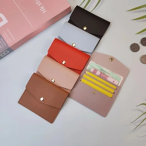 Detail of slim faux leather card holder showing multi-slot interior and metal snap closure