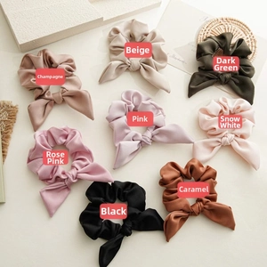 Detail shot of 8-color bow scrunchies with matte stripe texture on a warm background