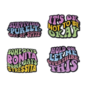 Set of four colorful enamel badges with creative English phrases on white background