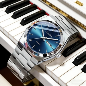 Detail view of silver steel band watch with blue dial and dual calendar display on piano