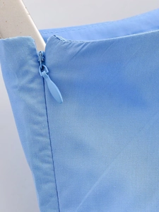 Dettaglio della cerniera invisibile su tessuto in saia azzurro di gonna midi moda