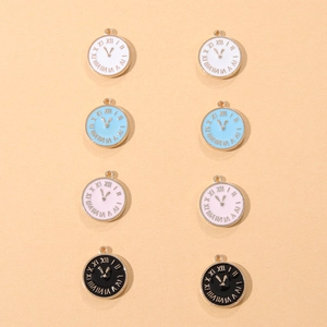 Detailed macro view of small enamel clock charms with Roman numerals for jewelry crafting