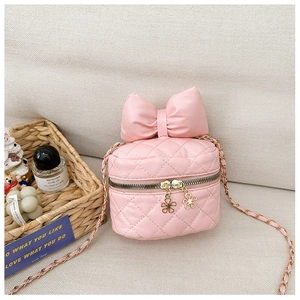 Detail of pink quilted PU leather bag with bow decoration and floral gold zipper pulls