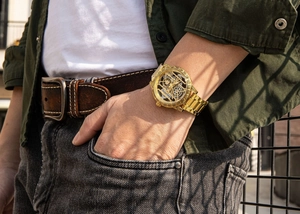 Détail de la montre squelette Successway dorée avec des gravures vintage sur le poignet