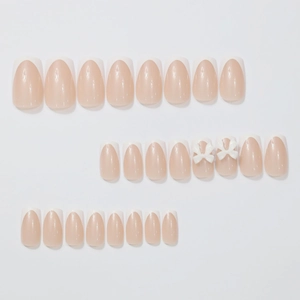 French tip press-on nails with white 3D bows and nude base in a set of multiple sizes